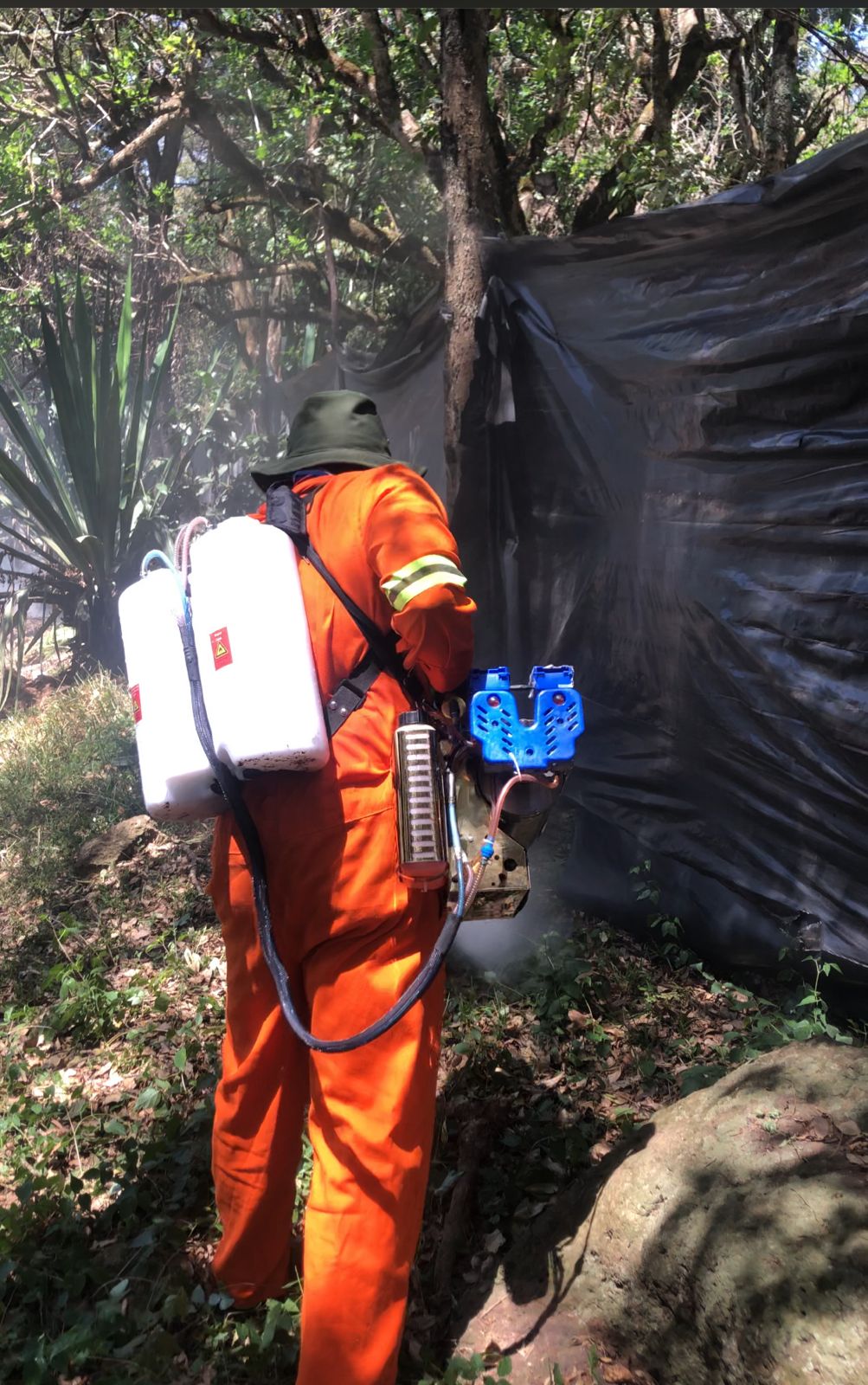 Kowa technician spraying under furniture